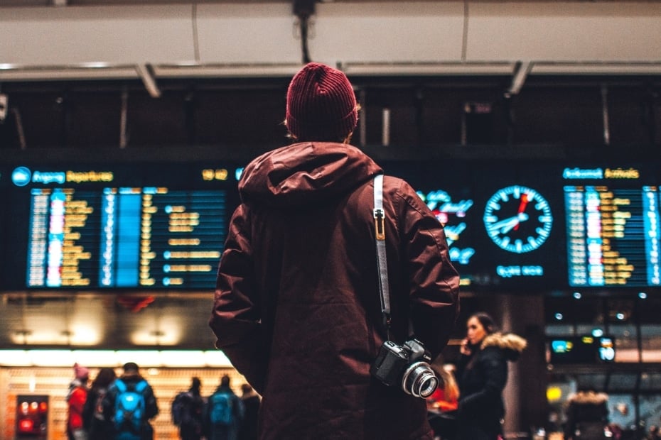 Flying To Korea: How To Get Cheap Flights To Korea In 2024 6 Man looking at a flight departure timetable