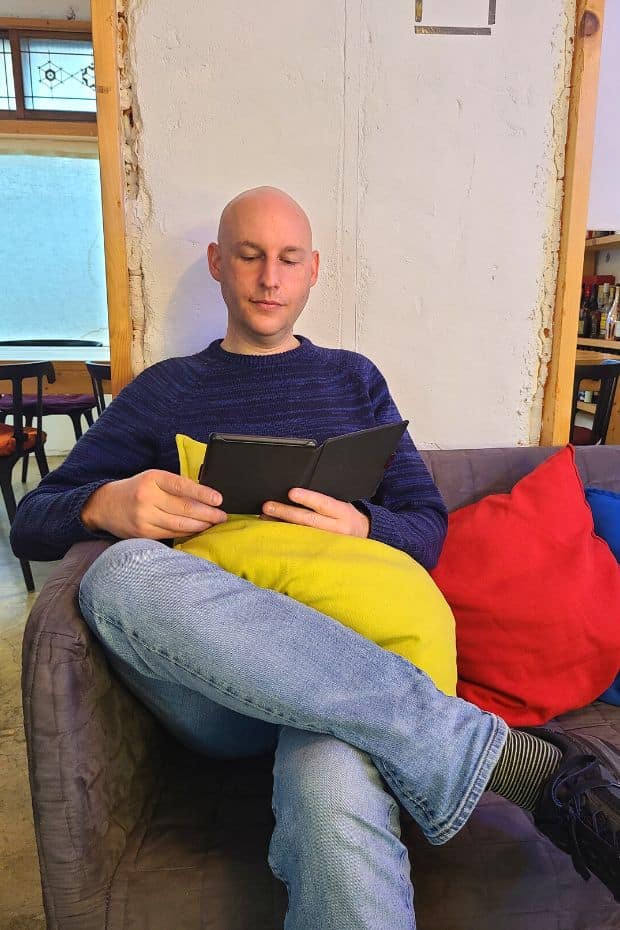 What To Do On Jeju Island In Winter: Jeju Winter Itinerary 2024 17 Man reading a book at Blue Haus Cafe In Seogwipo