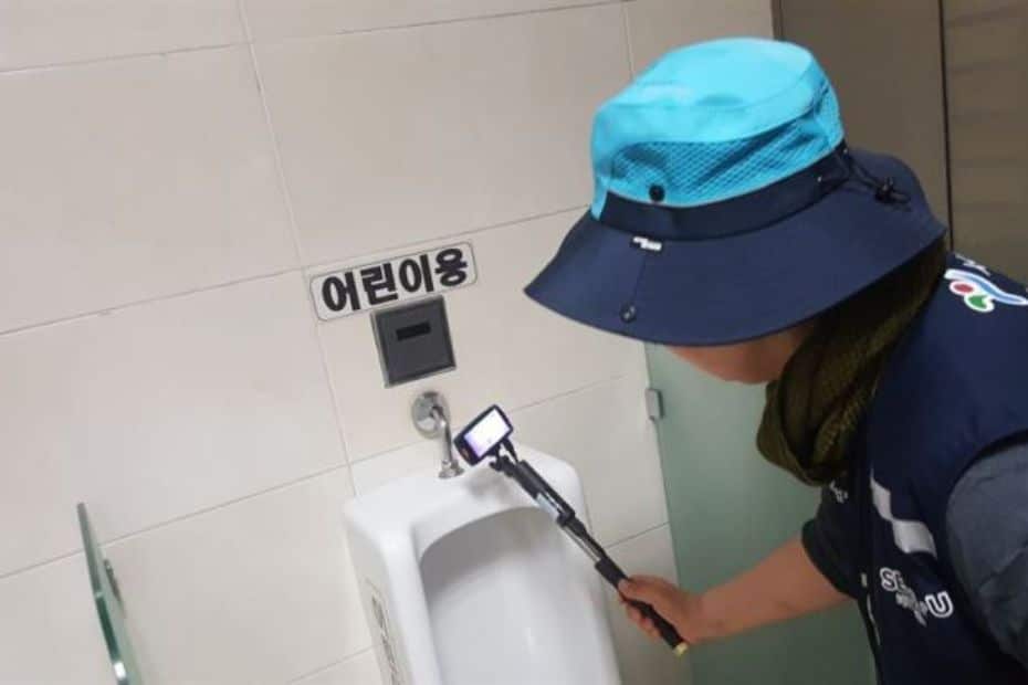 Korean Public Toilets: What Are Restrooms In Korea Like? 23 Person inspecting a Korean toilet for spy cameras
