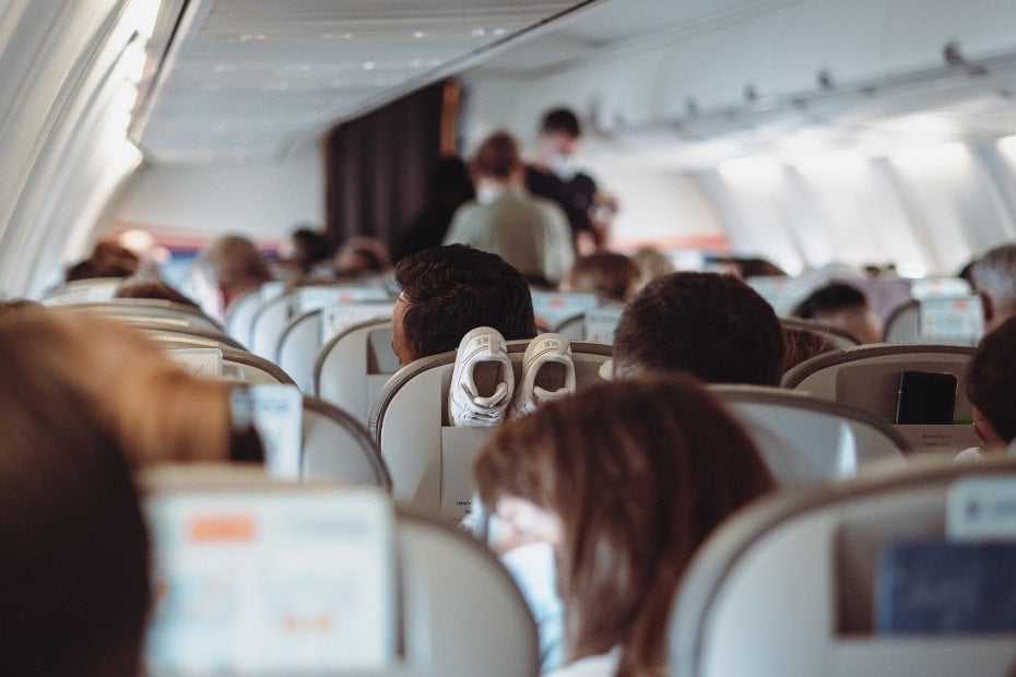 Flying To Korea: How To Get Cheap Flights To Korea In 2024 5 Person wearing a face mask on a flight