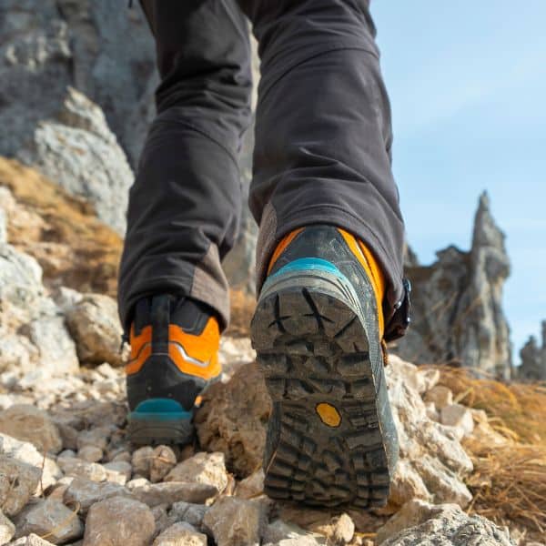 Person wearing hiking boots in mountains Person wearing hiking boots in mountains