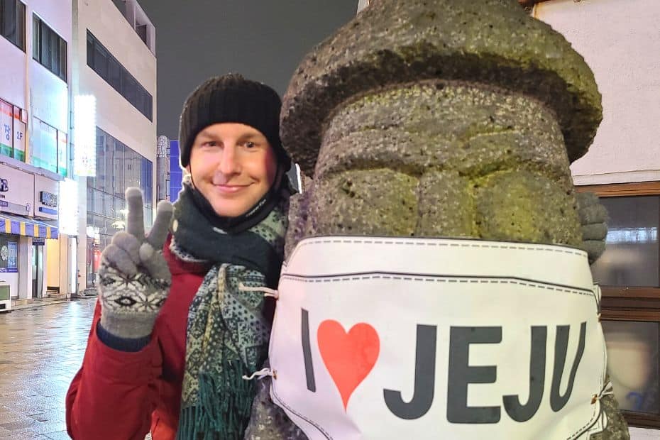 What To Do On Jeju Island In Winter: Jeju Winter Itinerary 2024 7 Standing next to a dol-hareubang in Jeju City