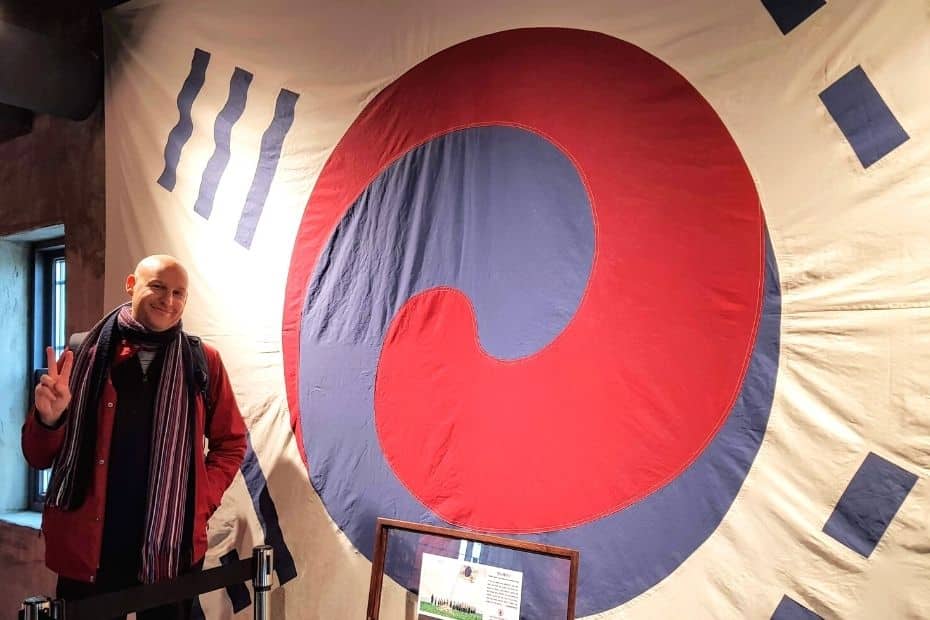 Expat Life In Korea: A Guide To Living In Korea As An Expat 22 Joel, an expat in Korea, standing by an old Korean flag